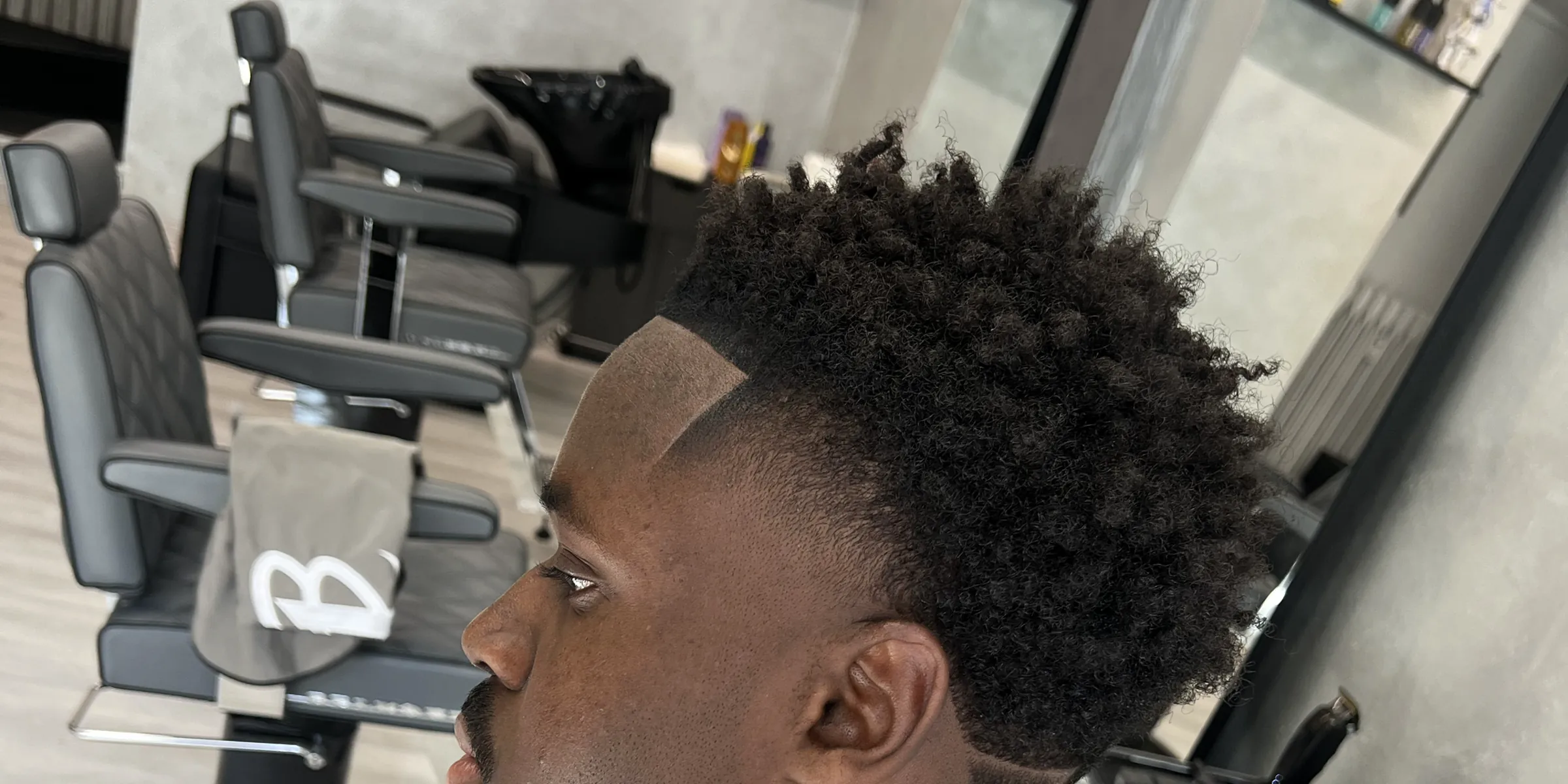 Lockiges Haar mit Drop Fade und gezogenen Konturen